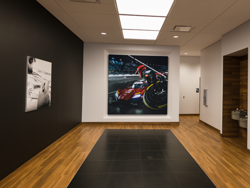 Mazda dealership hallway with race car wall art and wooden flooring