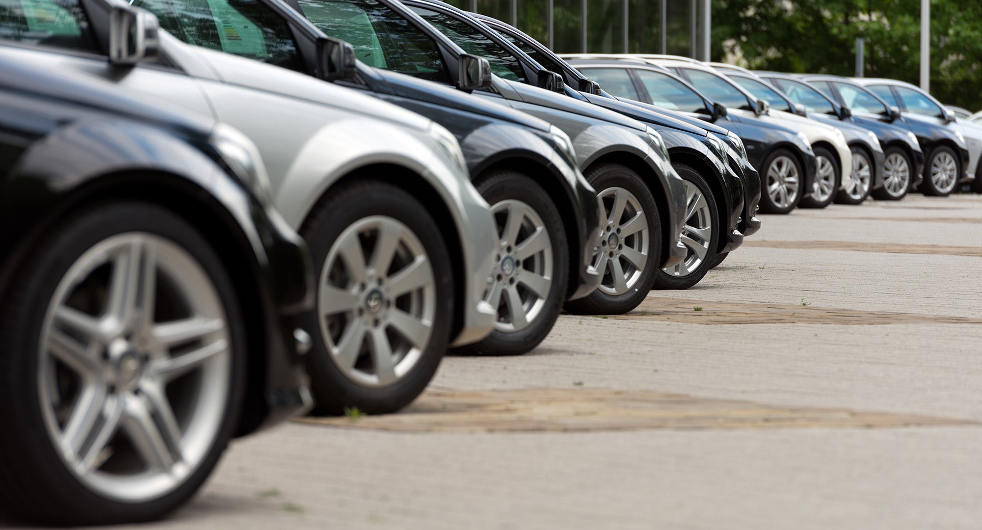 Line of black and silver cars parked in a dealership lot